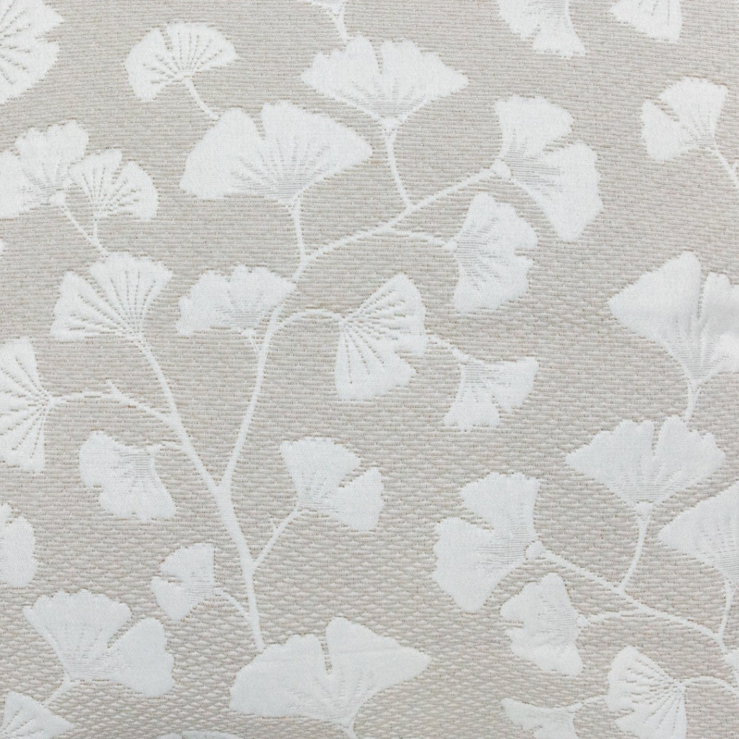 Jacquard‑Kissenhülle mit feinem Ginkgo‑Blattdesign in natürlichen Tönen, dekorativ auf einem Sofa platziert.