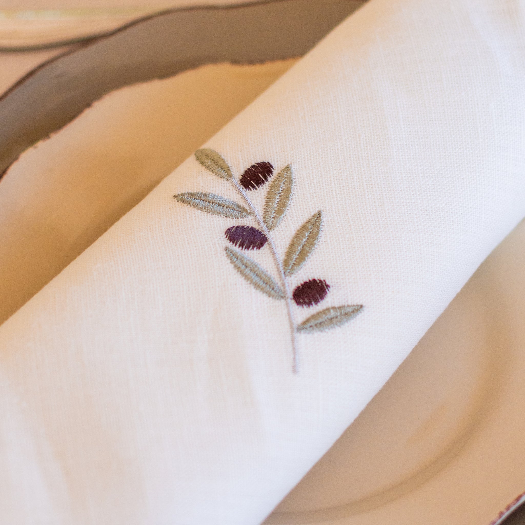 Serviette aus weißem Leinen mit feinem Olivenmuster – elegant, zeitlos und hochwertig verarbeitet.
