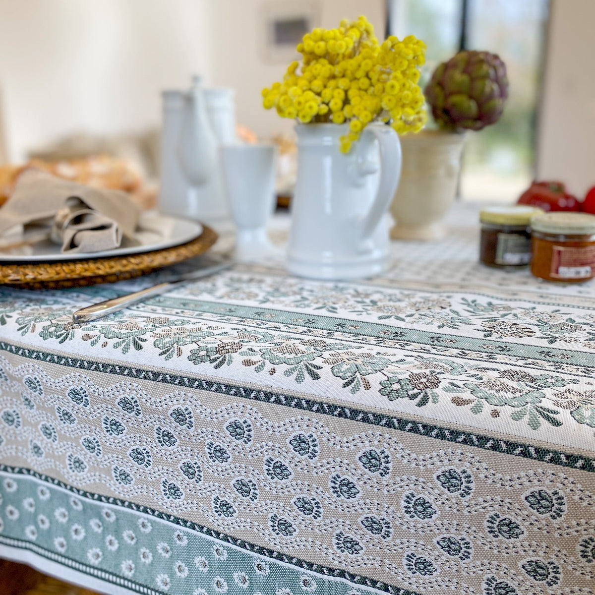 Tischdecke aus hochwertigem französischem Jacquardstoff in Grün, Beige und Weiß mit klassischem Muster, ideal für elegante Tischdekoration.