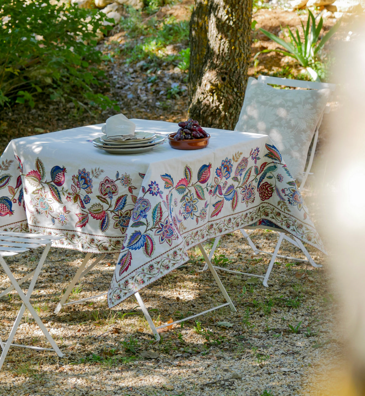 Französische Jacquard-Tischdecke mit floralem Muster in Rot, Blau und Grün auf weißem Grund und feinen goldfarbenen Akzenten.